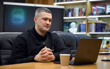 Михаил Федоров сидит за столом с ноутбуком, задумчиво размышляя о возможной роли лидера новой партии