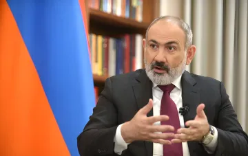 Armenischer Ministerpräsident Nikol Pashinyan während einer offiziellen Erklärung, mit der armenischen Flagge im Hintergrund, diskutiert das Referendum über den EU-Beitritt