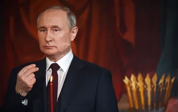 Владимир Путин с зажженной свечой на фоне иконы, символизирующий провокационные действия в контексте территориальных претензий к Польше