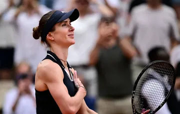 Ukrainische Tennisspielerin in schwarzer Sportkleidung und Visier mit Schläger vor verschwommenem Publikum, vorbereitet auf WTA 1000-Turniere in Nordamerika