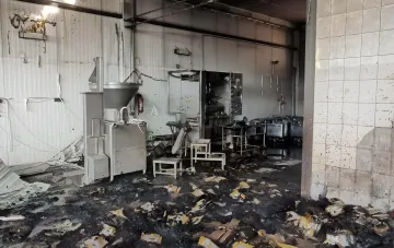 Destroyed workshop of Bohodukhiv dairy plant after strike: burnt equipment, debris and fire traces on the floor