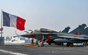 Французський винищувач Rafale на палубі авіаносця під прапором Франції: символ ядерного парасоля Парижа