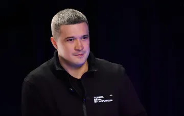 Михаил Федоров в черной куртке с надписью 'TURBO. DATA. INTEGRATION.' на фоне темного интерьера — момент, когда он раскрыл истинную причину своей отставки с поста министра обороны Украины