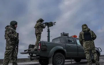 Ukrainian soldiers prepare an anti-aircraft system on a pickup truck to repel a drone attack