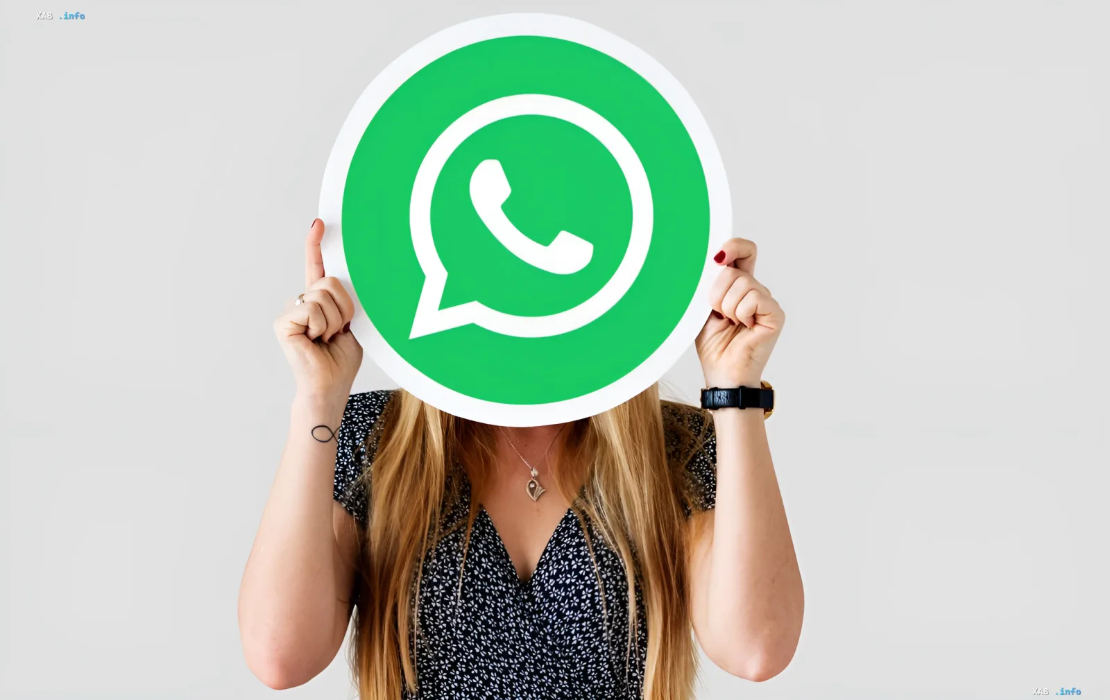 Женщина держит перед лицом логотип WhatsApp, символизируя переход к звонкам через браузер без установки приложения