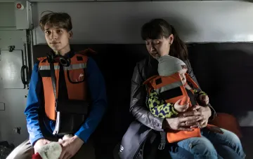 Семья с детьми в спасательных жилетах во время принудительной эвакуации из зоны обстрелов в Харькове