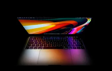 MacBook с ярким экраном, демонстрирующий интерфейс macOS, где может быть интегрирован Google Gemini для умного диктования и анализа экрана