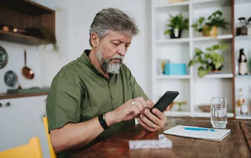 Предприниматель проверяет налоговые долги на смартфоне в приложении «Дія» или ЭК