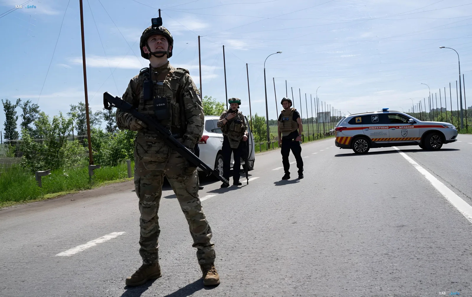Ukrainischer Soldat in Tarnkleidung mit Waffe und Helm mit Kamera steht auf der Straße und beobachtet den Himmel als Teil des FPV-Drohnen-Verteidigungssystems in Charkiw.