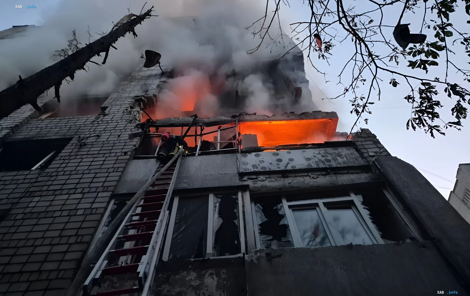 Пожар в многоэтажном доме во Львове после ракетного удара: спасатель на лестнице тушит огонь, из окон валит дым