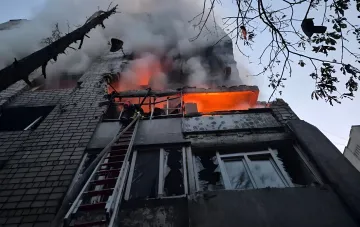 Пожар в многоэтажном доме во Львове после ракетного удара: спасатель на лестнице тушит огонь, из окон валит дым