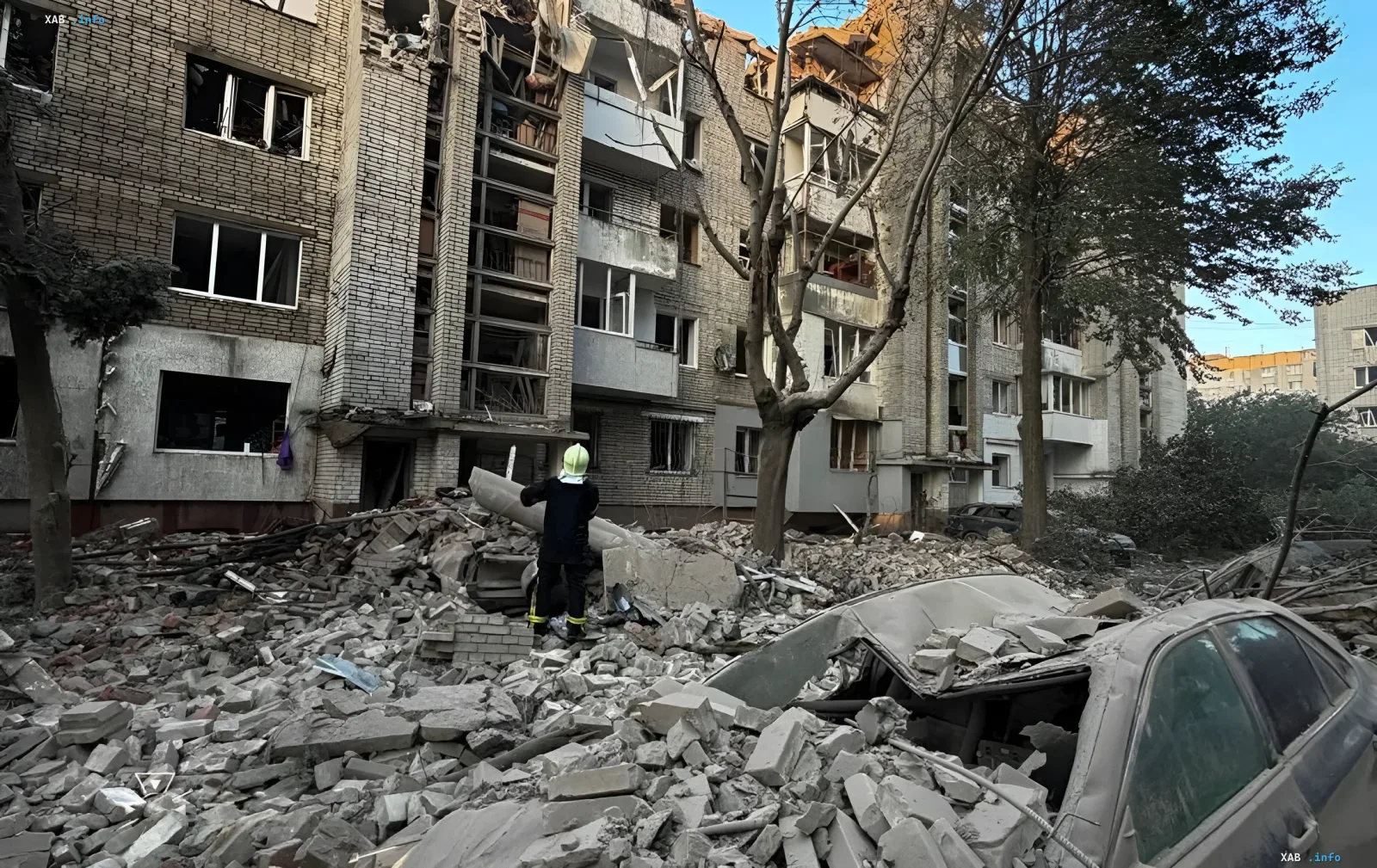 Спасатель в защитной экипировке осматривает завалы разрушенного жилого дома во Львове после удара
