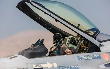 Пилот истребителя F-16 в кабине с открытым фонарем, готовый к вылету в рамках экстренного предупреждения Румынии из-за дронов у границы