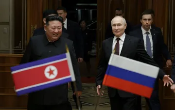 Vladimir Putin and Kim Jong Un with flags of Russia and North Korea, illustrating cooperation in the context of North Korean missile use