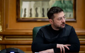 Президент Украины Владимир Зеленский за рабочим столом в кабинете, подписывает указ о Дне финансистов — новый государственный праздник