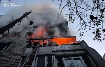 Пожар в здании после ракетной атаки, пожарные тушат огонь