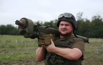 Украинский боец с противотанковым ракетным комплексом на фоне полей, готовясь к обороне от российских атак