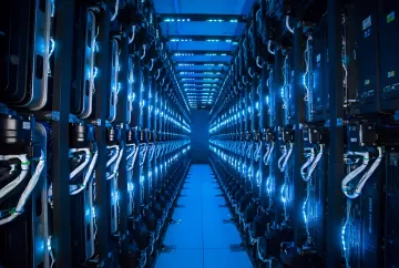 Reihen von Servern in einem Microsoft-Rechenzentrum, beleuchtet von blauem Licht, die massive Investitionen in Cloud-Technologien und KI symbolisieren