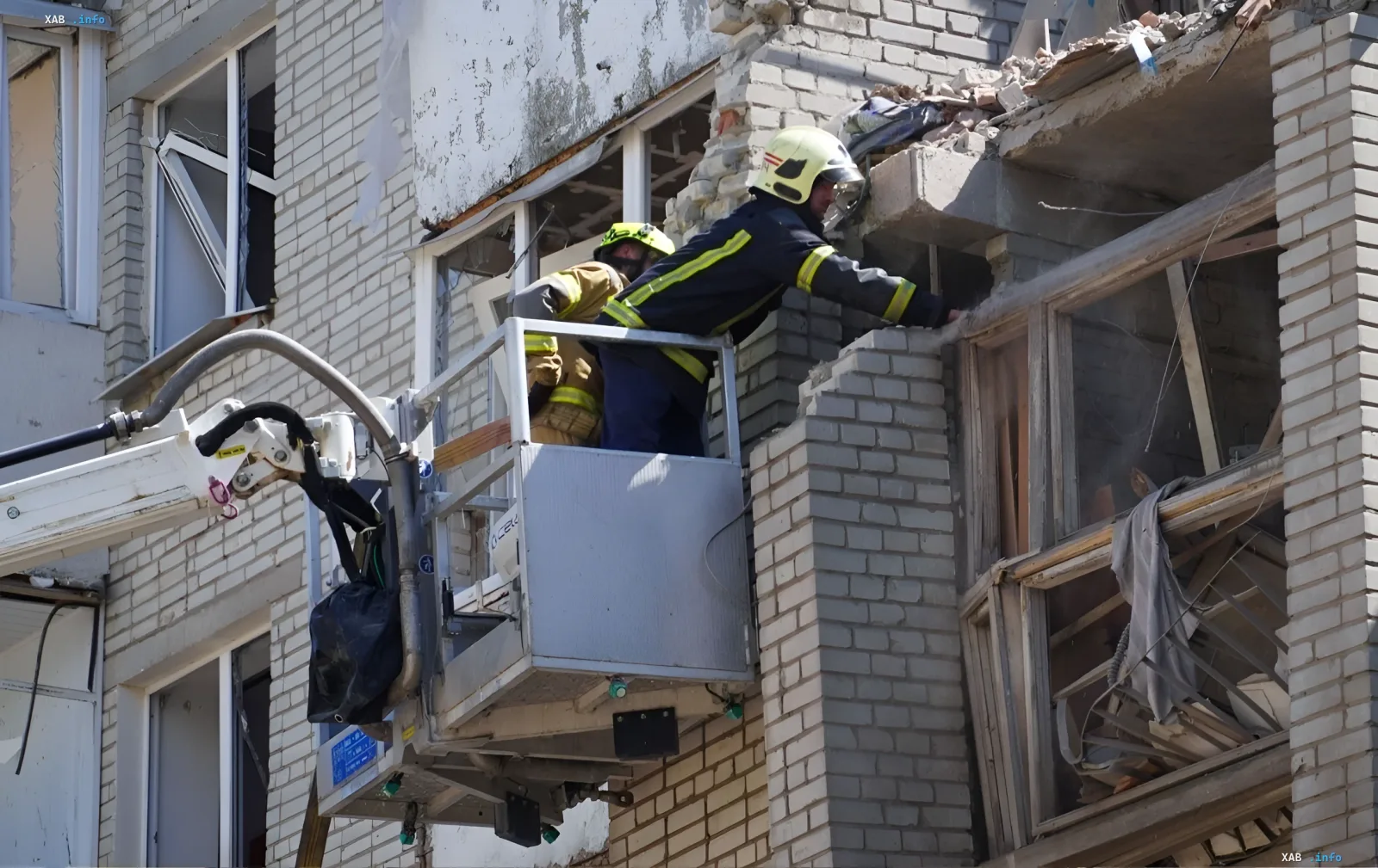 Пожарные спасатели на автовышке осматривают разрушенный фасад жилого дома после ракетной атаки в Львове