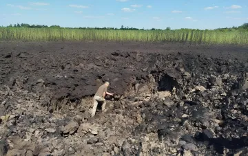 След от падения ракеты KN-23 вблизи Радушного: кратер и обугленная земля, где человек осматривает последствия удара