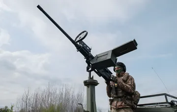 Украинский военнослужащий управляет зенитной установкой ПВО во время отражения атаки дронов над Киевом утром 31 июля