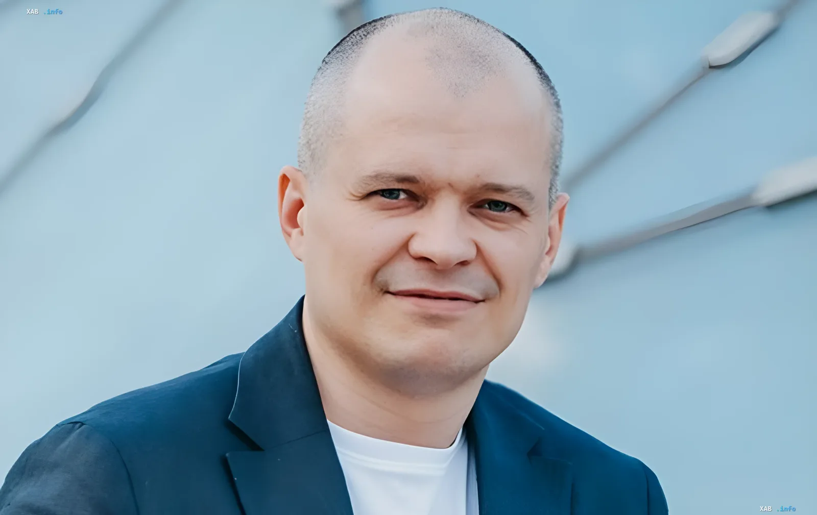 Бизнесмен в синем пиджаке на фоне современной архитектуры — символ украинского предпринимательства, защищённого долгосрочными энергетическими аукционами