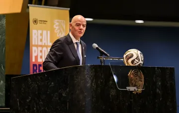 Президент ФИФА Джанни Инфантино выступает с речью в ООН, на трибуне лежит футбольный мяч, иллюстрируя отмену продажи долей в ЧМ под давлением бойкота