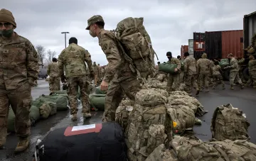 Військовий США з рюкзаками та речами в Європі, що ілюструє проблему логістики та дефіциту ресурсів для захисту Ізраїлю