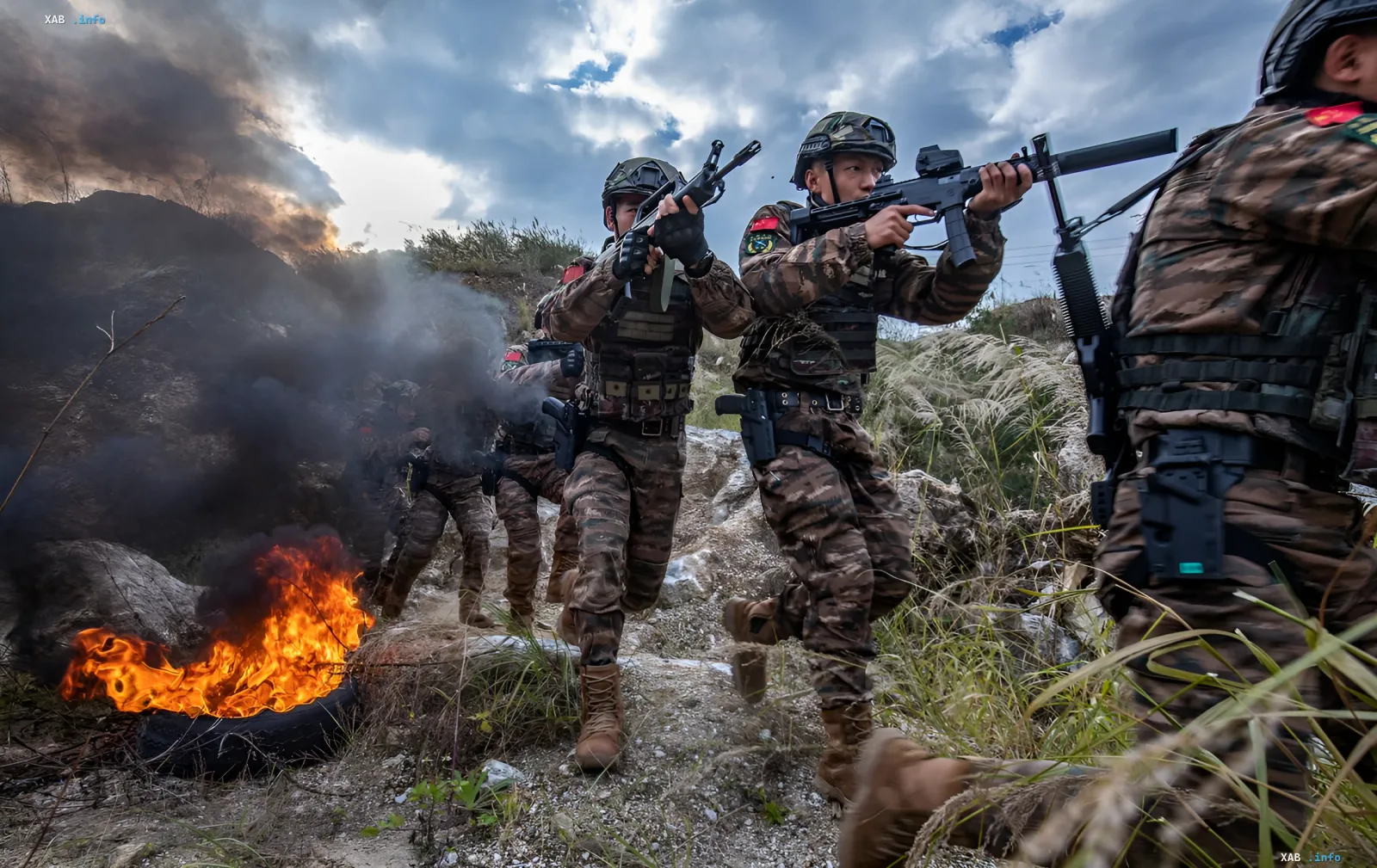 Chinesische Soldaten in Tarnanzug mit modernen Gewehren laufen durch ein Feld mit Feuer und Rauch, was militärische Übungen und technologische Anpassung symbolisiert