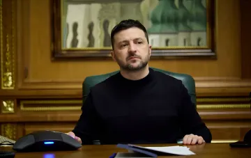 Ukrainian President Volodymyr Zelenskyy at his desk in an official office, discussing enhanced Black Sea security with UAE in exchange for experience combating Shahed kamikaze drones