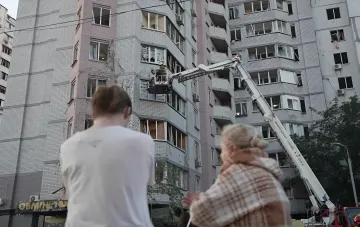 Спасатели на автолестнице работают у разрушенного жилого дома в Киеве после ночной атаки