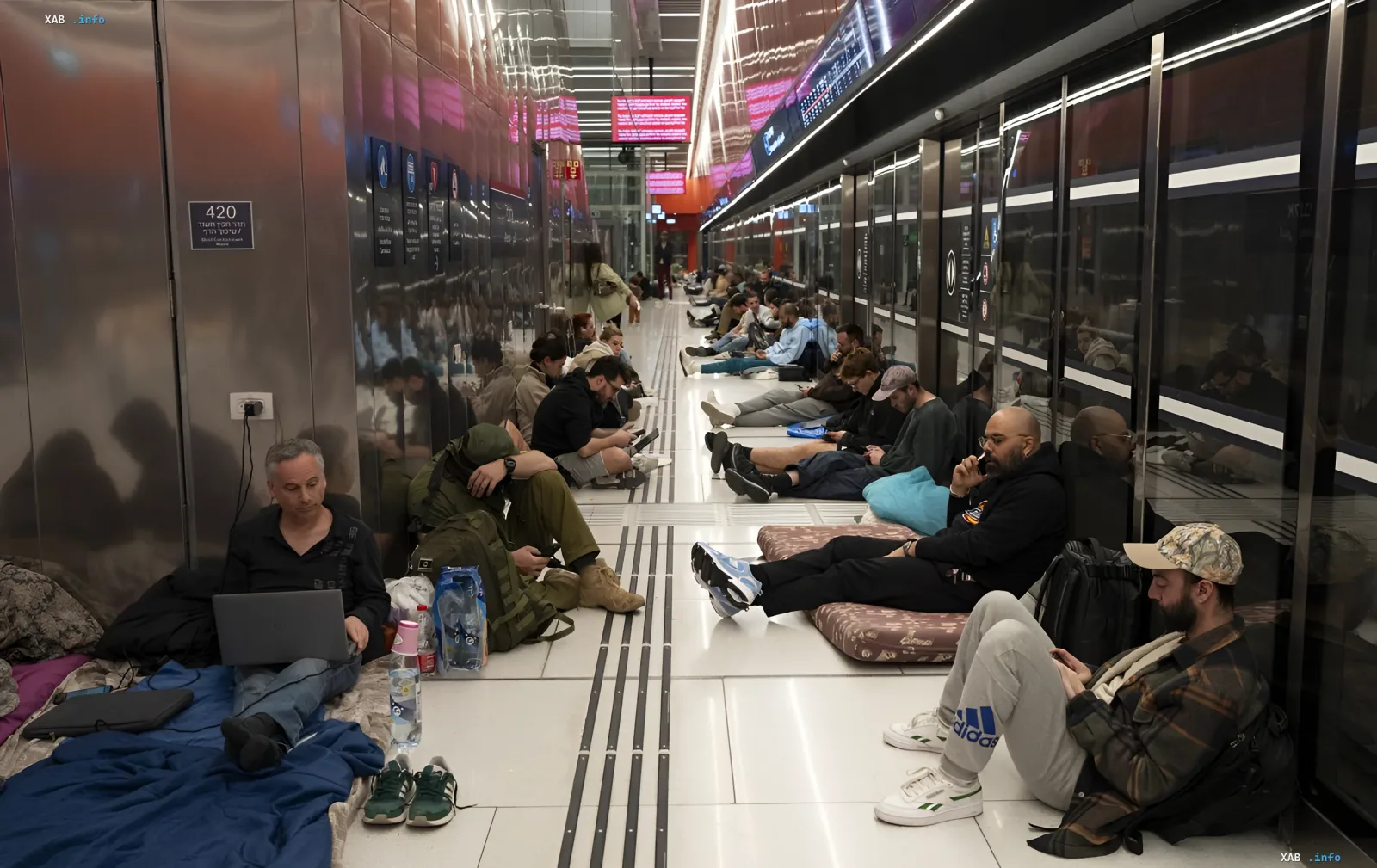 People resting on the floor in an underground passage or subway station in Israel, awaiting evacuation or flight cancellations due to escalating tensions in the Middle East