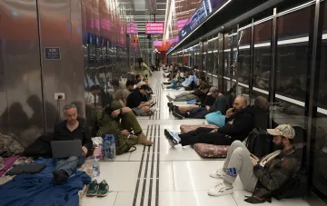 Люди отдыхают на полу в подземном переходе или станции метро в Израиле, ожидая эвакуации или отмены рейсов из-за эскалации напряженности на Ближнем Востоке