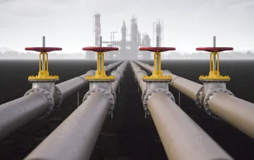 Kirkuk-Ceyhan oil pipeline: pipes with shut-off valves against the backdrop of an oil refinery, illustrating the strategic route for transporting oil from Iraq to Turkey