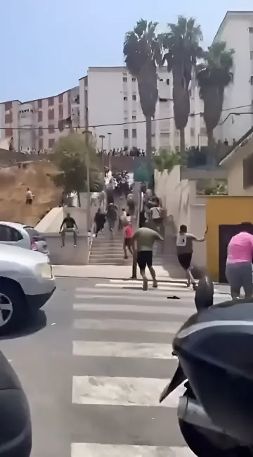 Массовые беспорядки в Сеуте: жители с палками и камнями бегут по улице, пытаясь остановить поток мигрантов