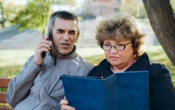 Пенсионеры обсуждают документы по телефону, планируя оформление пенсии с учетом зарубежного стажа
