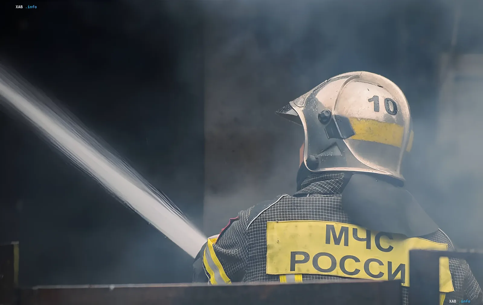 Russian EMERCOM firefighter extinguishing fire amidst smoke after drone attack on Saratov