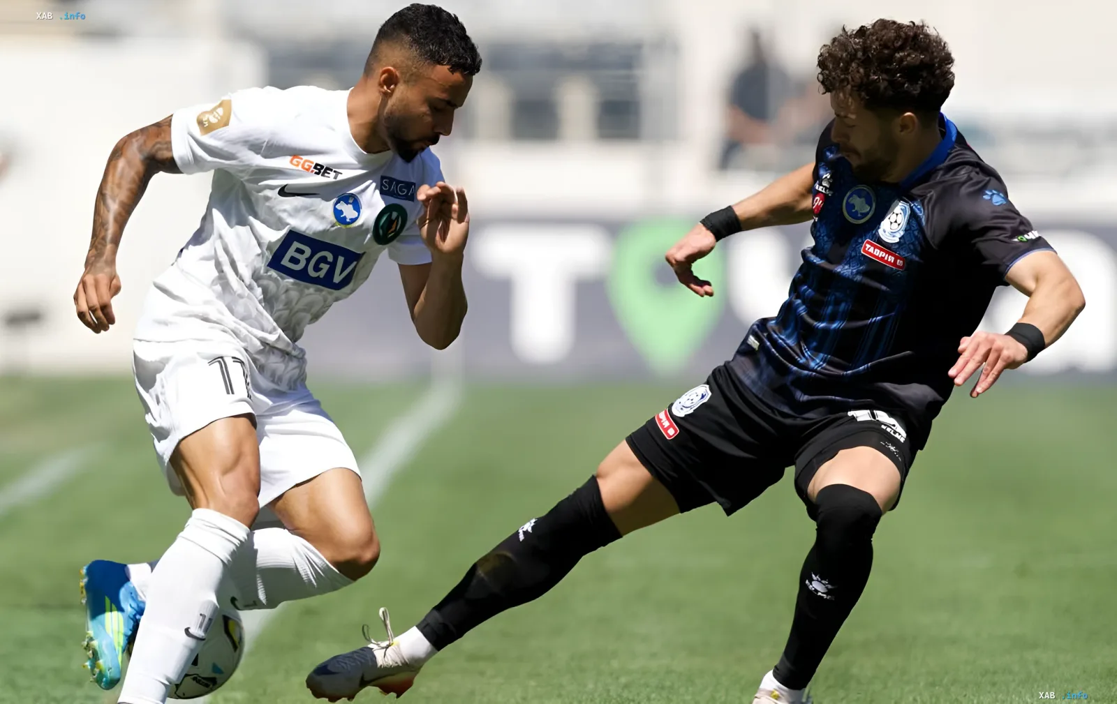 Spieler von Chornomorez im weißen Trikot mit BGV- und GG.BET-Logos kämpft um den Ball gegen einen Gegner im dunkelblauen Trikot — entscheidender Moment des Eröffnungsspiels der UPL 2026/27, bei dem Polissya Rache nahm