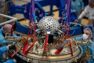 Engineers in a clean room assembling a high-precision space instrument for measuring gravity and spacetime curvature