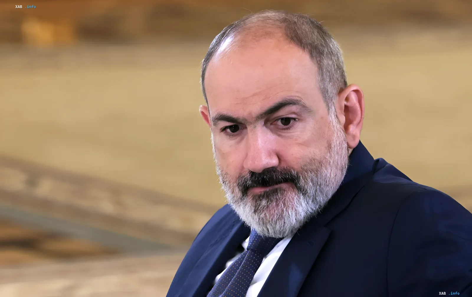 Nikol Pashinyan in a business suit against an official interior backdrop, symbolizing the resumption of his political role in forming Armenia’s new government