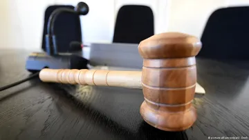 Судебный молоток на столе в зале суда в Варшаве — символ решения по делу об освобождении организатора нападений на российских оппозиционеров
