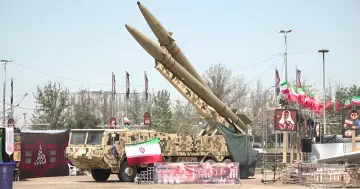 Иранская зенитная ракетная система на параде с флагом Ирана, символизирующая напряженность в Ормузском проливе на фоне переговоров с Трампом