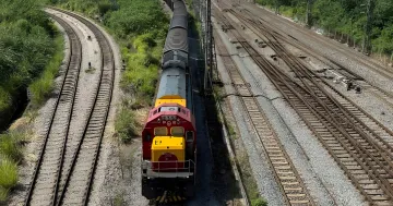 A freight train with a red locomotive moves along railway tracks, symbolizing accelerated deliveries of air conditioners from China to Europe via the 'Belt and Road' initiative to combat heat.