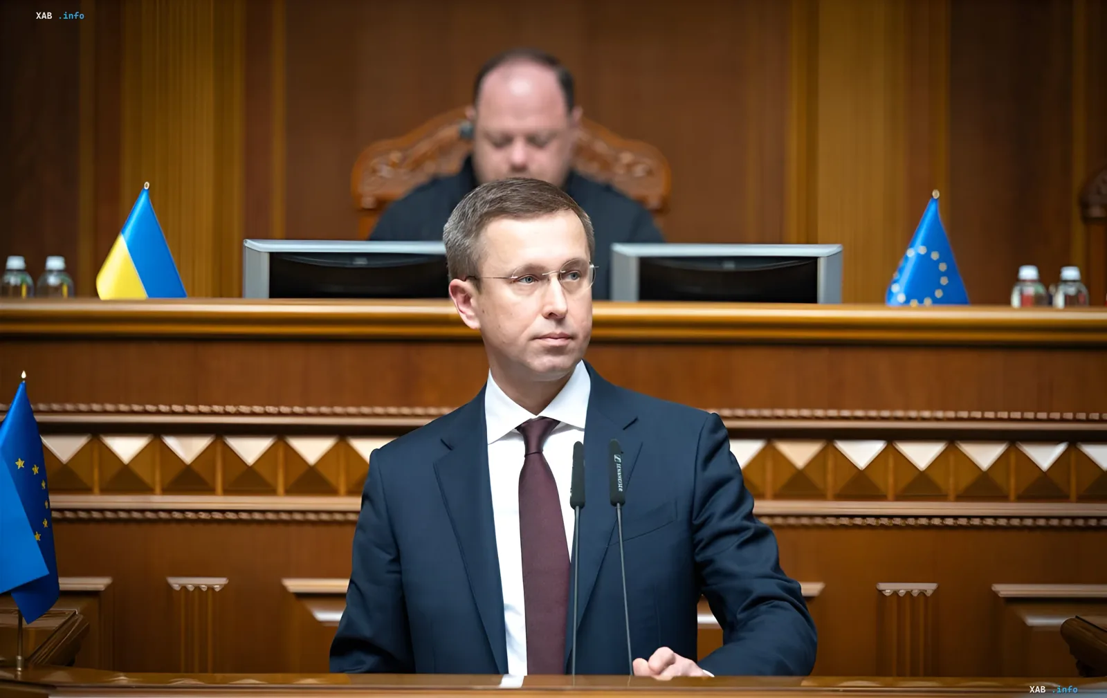 Министр финансов Украины Сергей Марченко выступает с речью в парламенте на фоне флагов Украины и ЕС, обсуждая бюджет на войну и финансирование на 2026 год