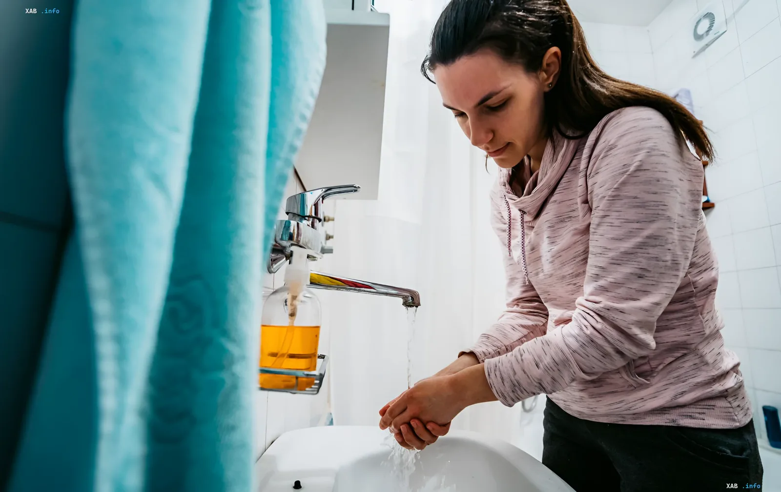 Woman washing hands at bathroom sink — illustration for article on utility bills for IDPs: when it’s legal not to pay for water, electricity and gas