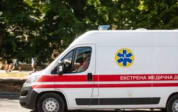 Скорая помощь в Одессе после российской атаки: машина экстренной медицинской службы на фоне движения, символизирующая срочную помощь пострадавшим детям и взрослым