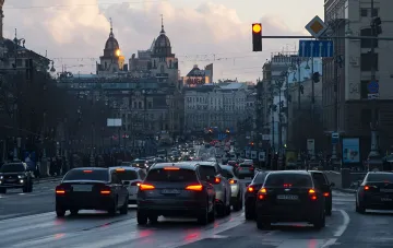 Городская пробка на закате: автомобили с включенными стоп-сигналами и поворотниками демонстрируют важность правильной перестройки и уступки дороги
