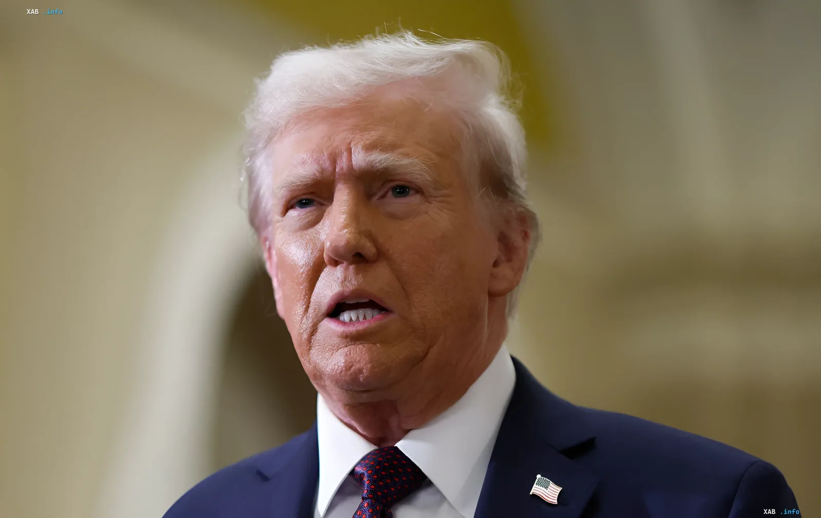 Дональд Трамп в деловом костюме с американским флагом на лацкане, обсуждающий ультиматум Ирану