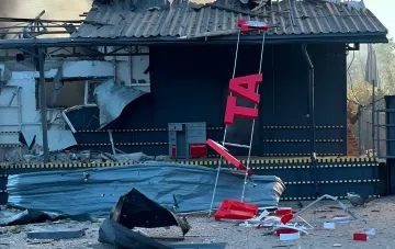 Разрушенное здание грузового отделения Новой почты в Прилуках после удара, видны обломки и поврежденный логотип