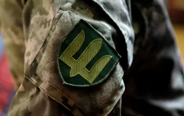 Патч с символом украинской армии на камуфляжной форме, символизирующий возвращение раненых бойцов на фронт